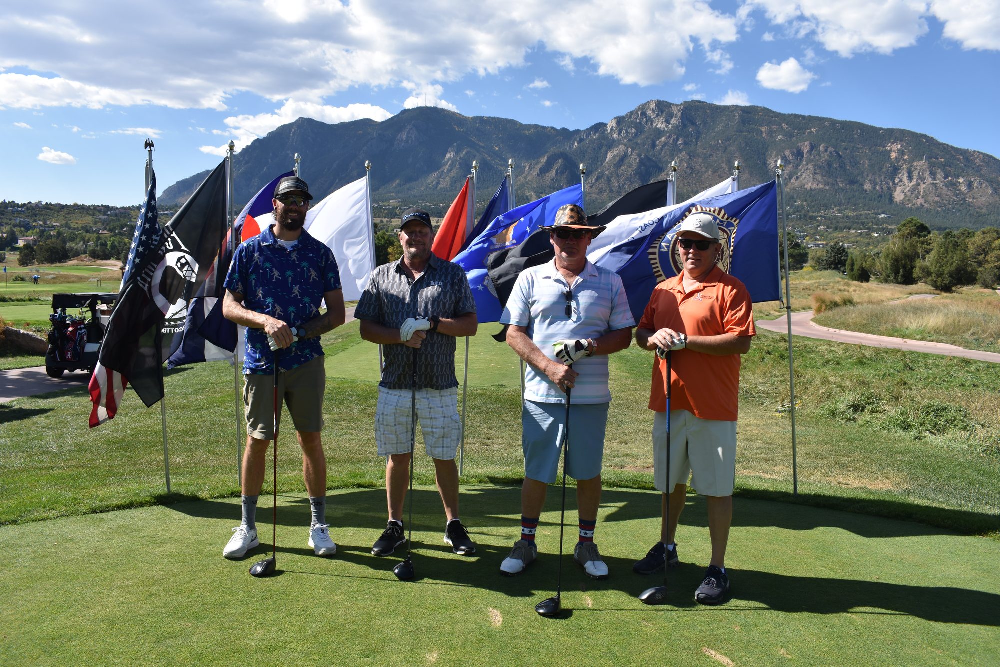 A foursome standing among the service flags before their round