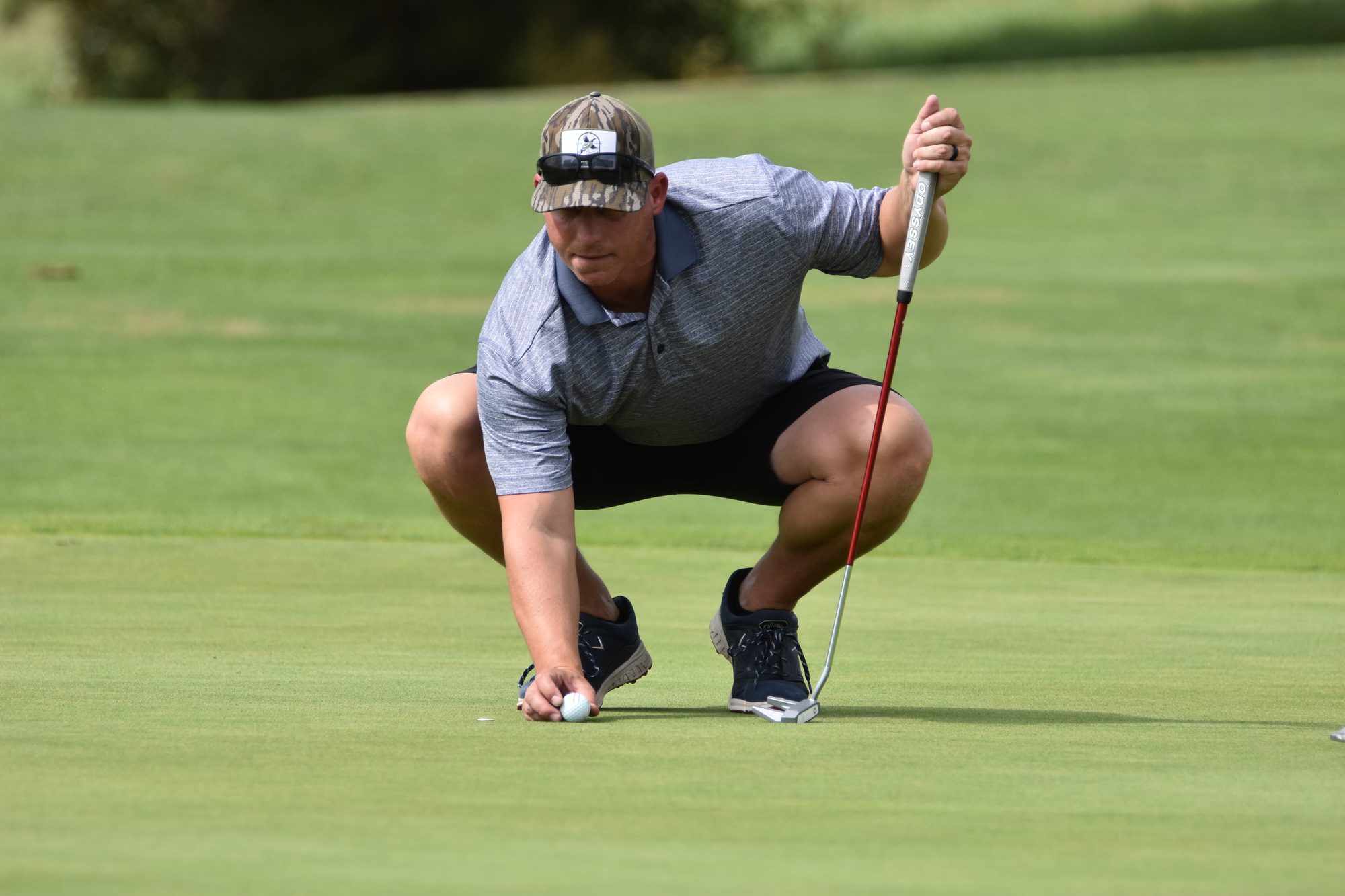 A golfer lining up a putt at the ALYP tournament