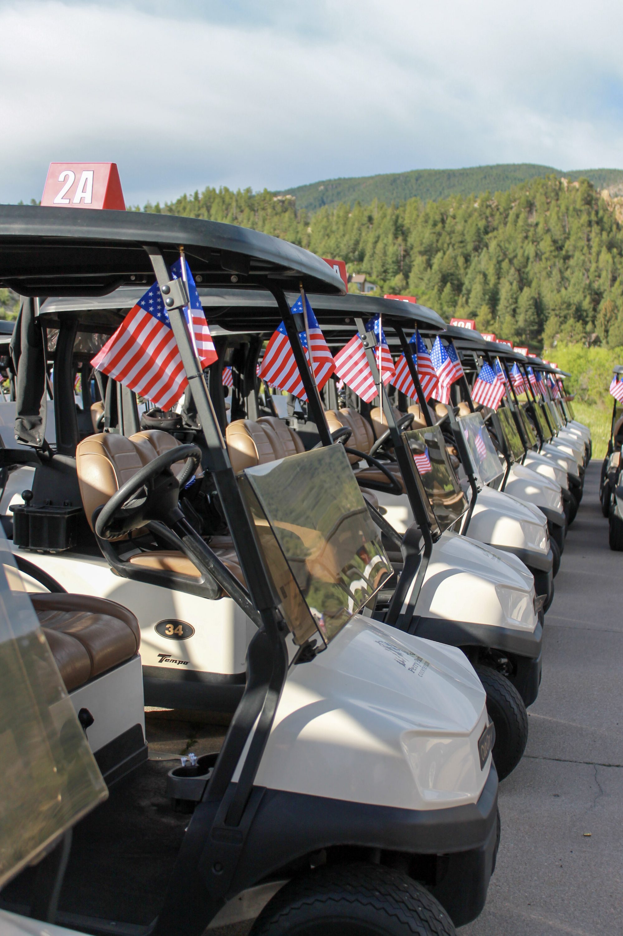 A line of golf carts flying American flags before the start