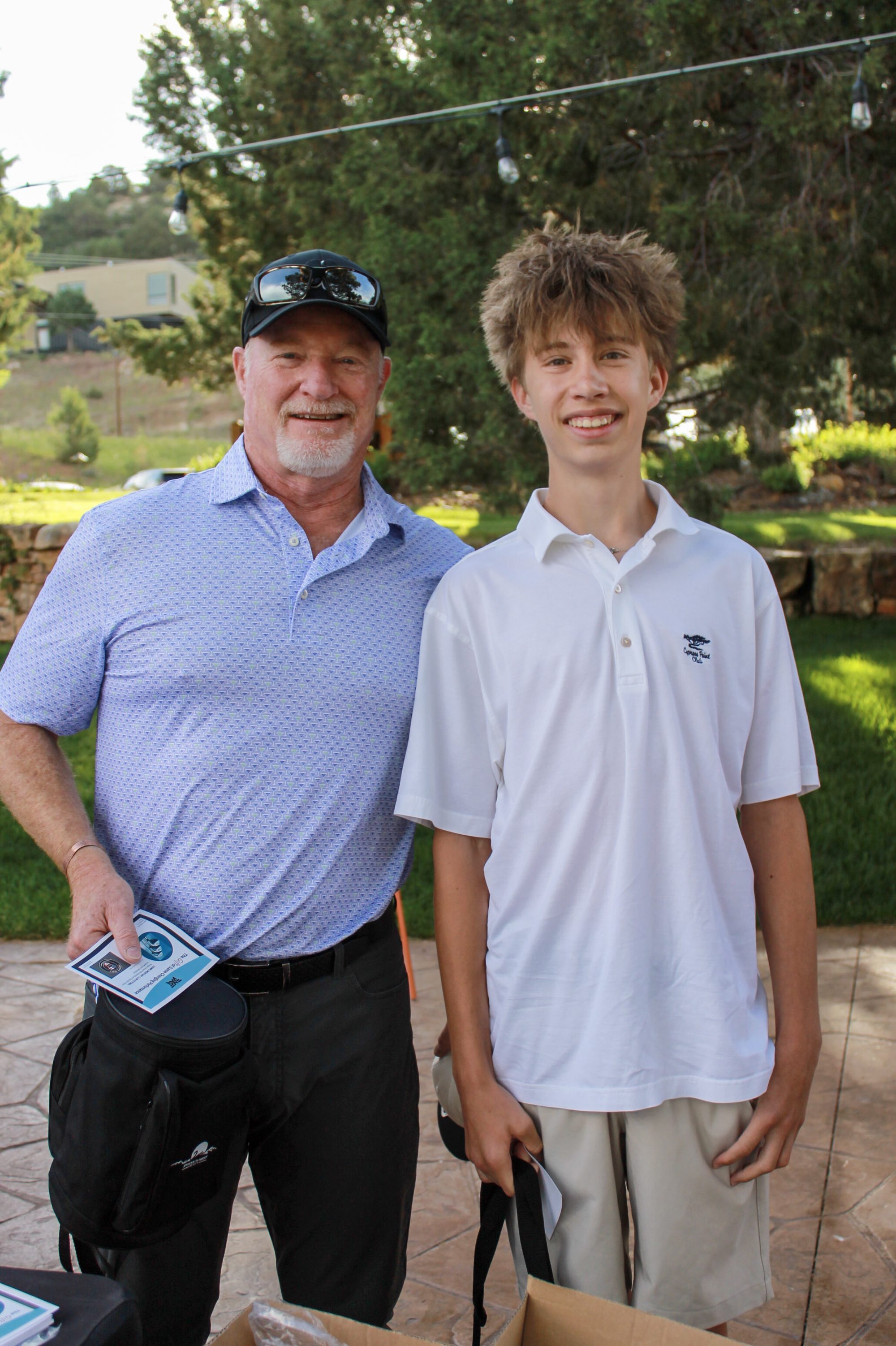 An adult and a young golfer at the clubhouse